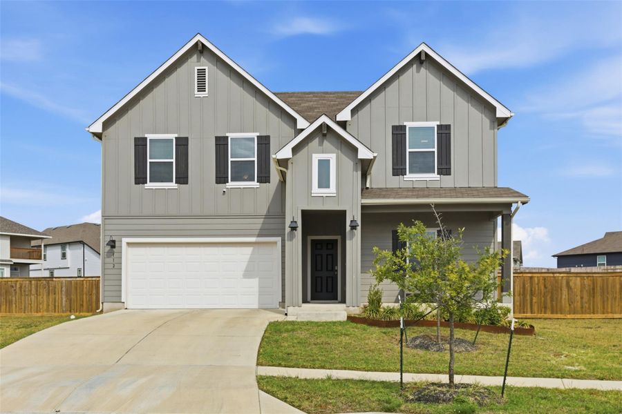 View of front of home featuring board and batten siding, a garage, and concrete driveway