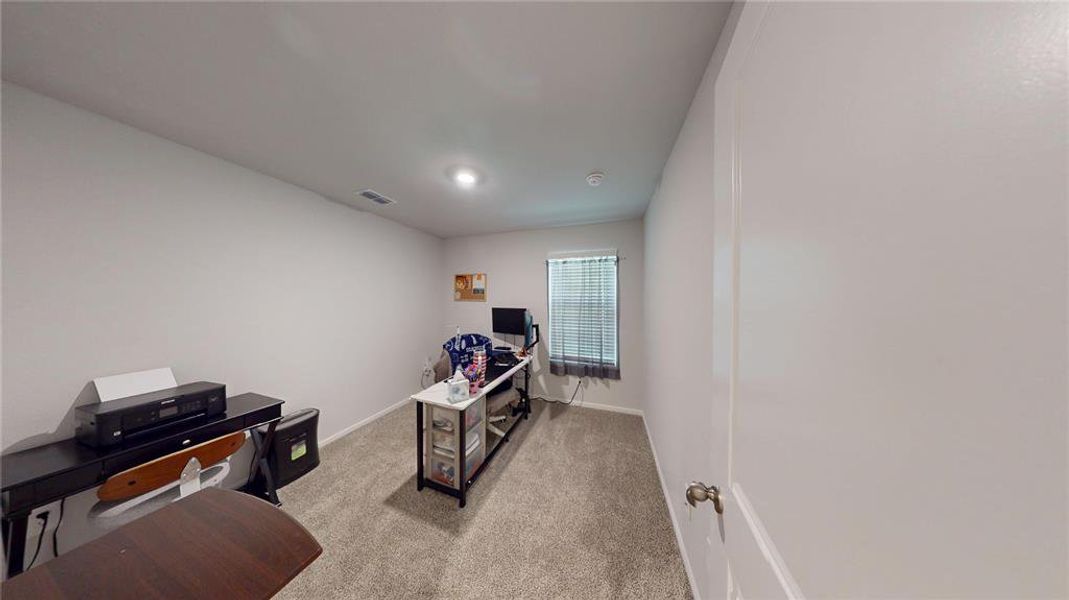 Carpeted room with neutral wall tones and a window featuring horizontal blinds