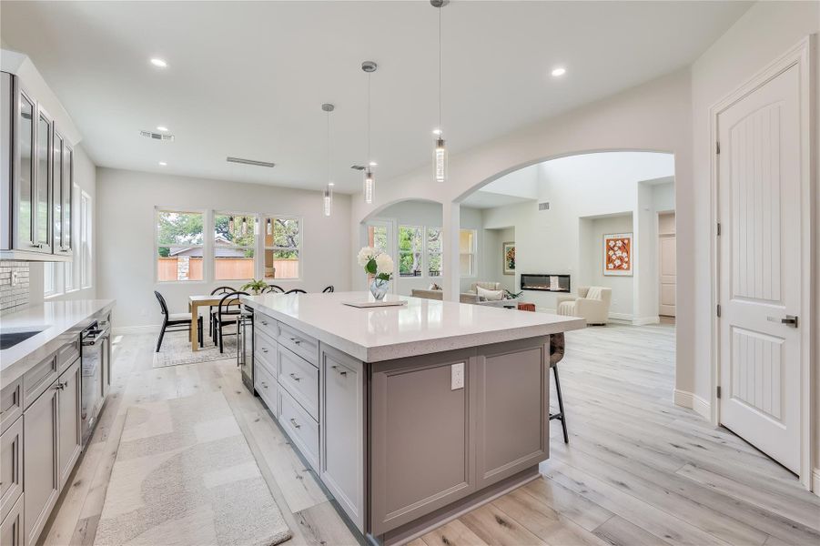 Kitchen featuring pendant lighting, a kitchen island, gray cabinets, a breakfast bar, and light hardwood / wood-style flooring