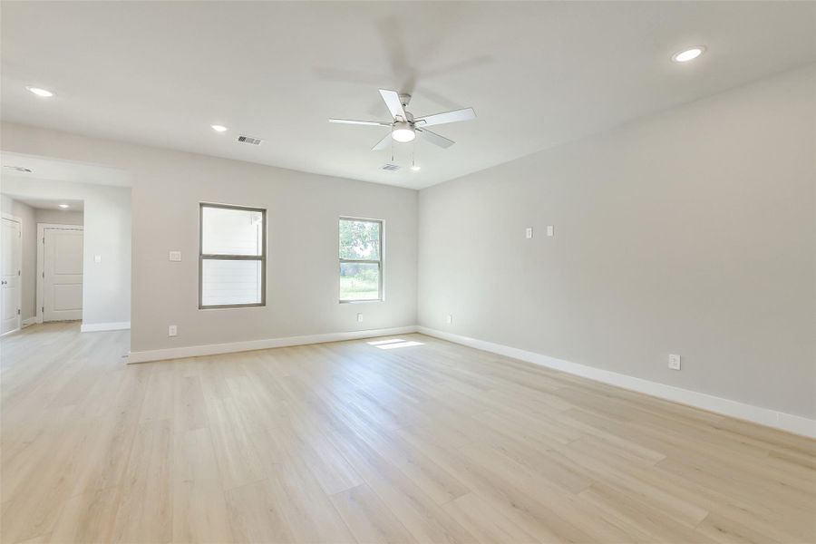 Open and versatile living area with multiple windows bringing in great natural light and views of the yard.