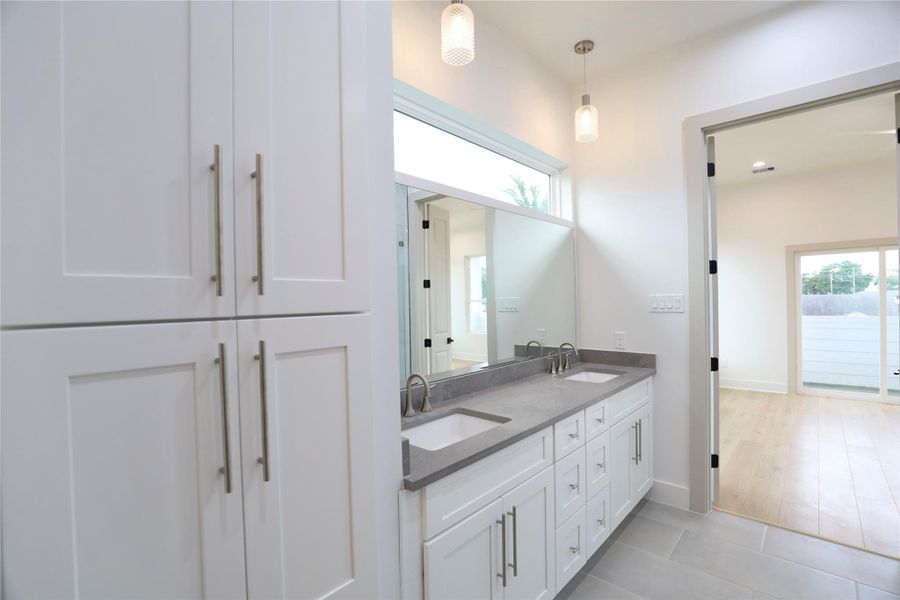 Your primary bath is a storage oasis, featuring a spacious linen closet with soft-close cabinetry and elegant 10" hardware. Two French doors lead into the tranquil primary suite bedroom. Your primary bath is a storage oasis, featuring a spacious linen closet with soft-close cabinetry and elegant 10" hardware. Two French doors lead into the tranquil primary suite bedroom.