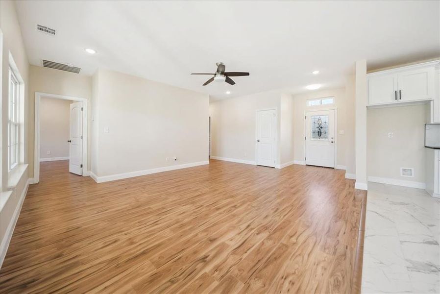 Unfurnished living room featuring light wood-type flooring and ceiling fan