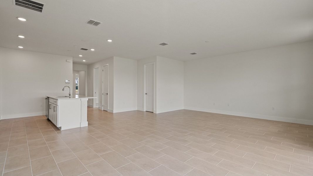 Living Area and Kitchen in the Buttonwood floorplan by DRB Homes at Lakeside at Satilla in Saint Cloud, FL