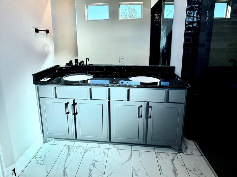 Bathroom with light marble finish floors, double vanity, and a shower stall Bathroom with light marble finish floors, double vanity, and a shower stall