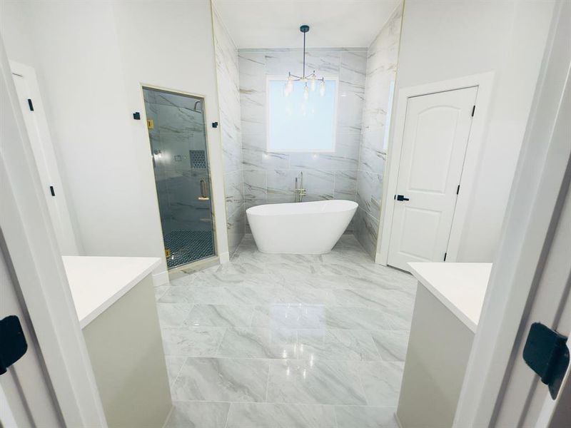 Bathroom featuring vanity, an inviting chandelier, and separate shower and tub