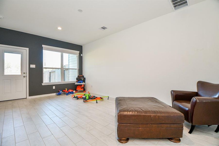 How cool is this! A spacious flex room with wood-look tile flooring, designer paint, and patio access offers endless possibilities to suit your needs.