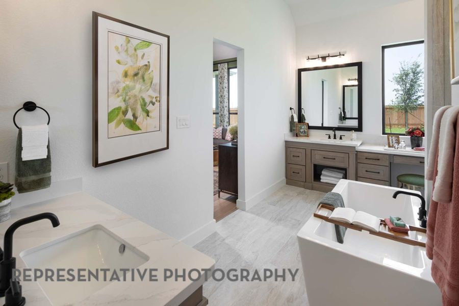 Ensuite bathroom featuring vanity, wood finished floors, baseboards, ensuite bathroom, and a soaking tub Ensuite bathroom featuring vanity, wood finished floors, baseboards, ensuite bathroom, and a soaking tub