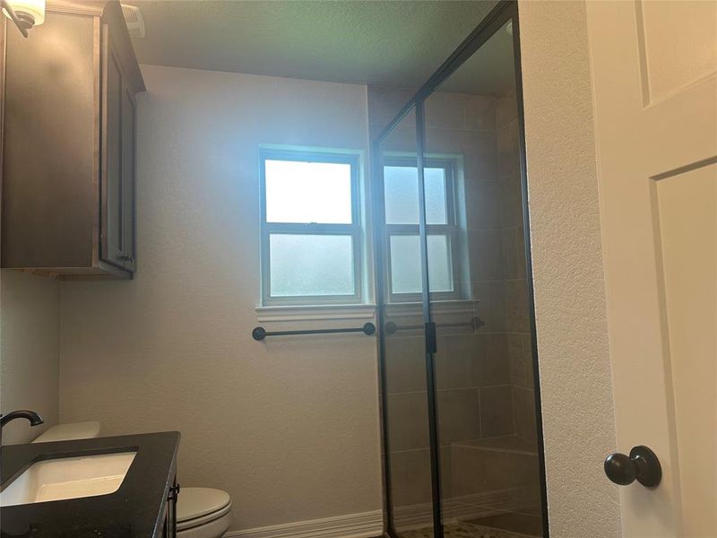 Full bath with a shower stall and vanity