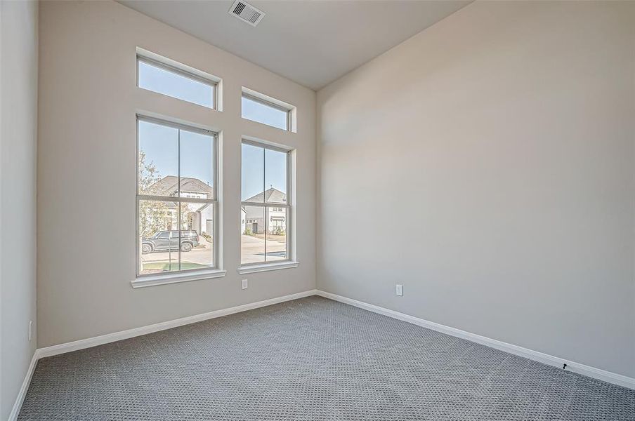 Two secondary bedrooms (Pictured 1 of 2) are located at the front of the home, offering walk-in closets and elegantly designed bathrooms with white marbled tile flooring, mud-set walk-in showers with benches, and black granite countertops with gold hardware.