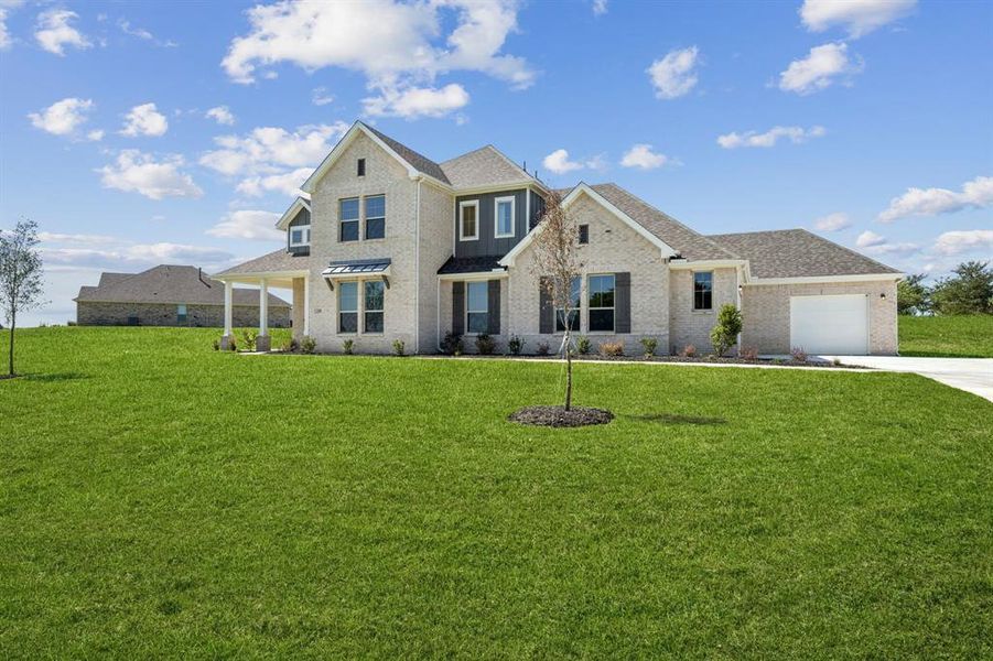 View of front of property featuring a front yard, brick siding, driveway, a garage, and roof with shingles