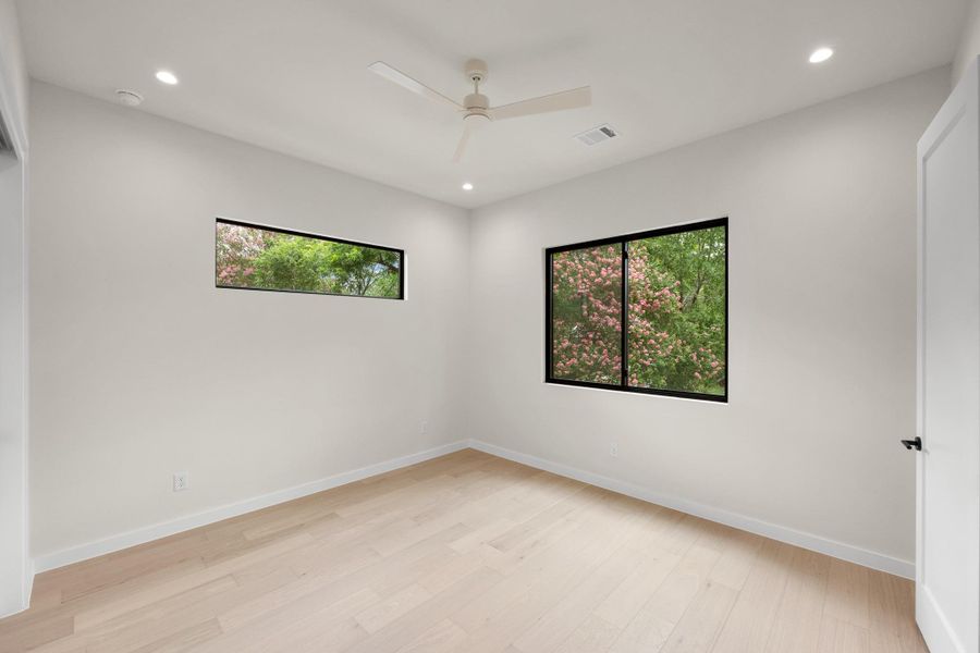 Blonde hardwood floors and large windows define this luminous, airy bedroom. Blonde hardwood floors and large windows define this luminous, airy bedroom.