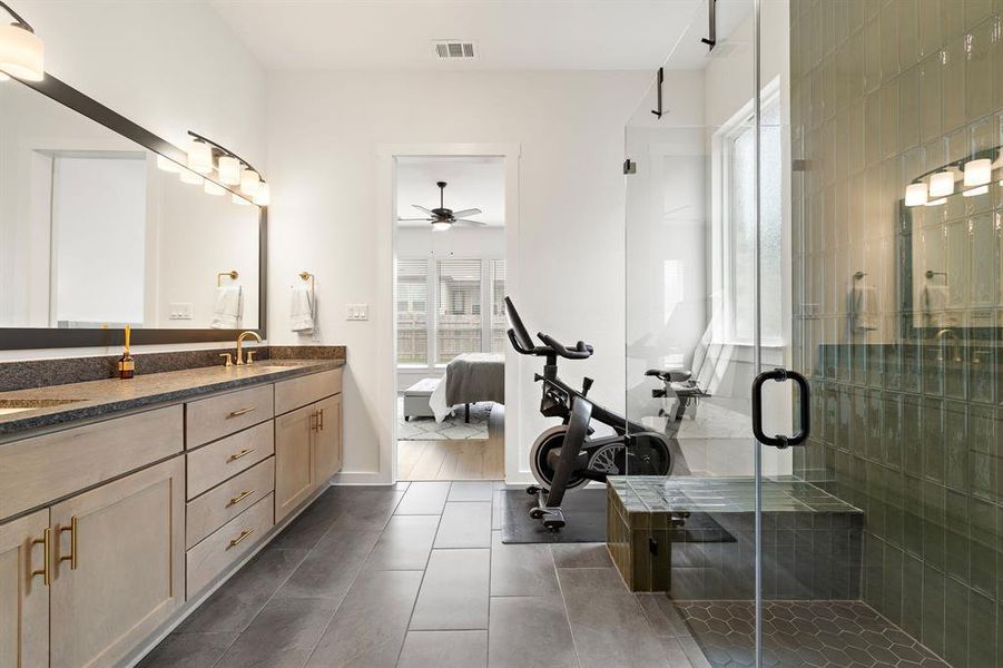 A well-appointed primary bathroom showcases dual vanities, sleek tile flooring, and a spacious glass-enclosed shower. A well-appointed primary bathroom showcases dual vanities, sleek tile flooring, and a spacious glass-enclosed shower.