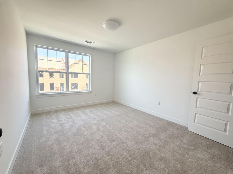 Unfurnished room with baseboards and light colored carpet