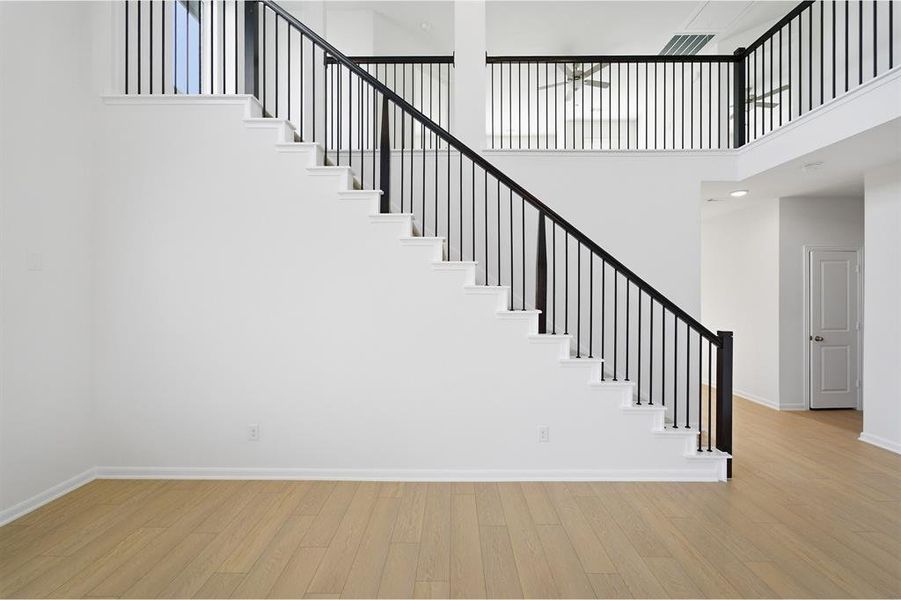Stairs featuring wood finished floors and a high ceiling