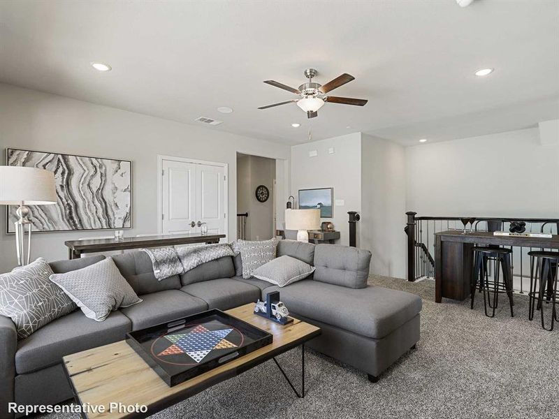 Carpeted living room featuring ceiling fan