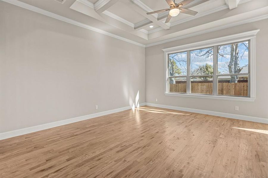 Unfurnished room with coffered ceiling, beam ceiling, ornamental molding, and light hardwood / wood-style floors