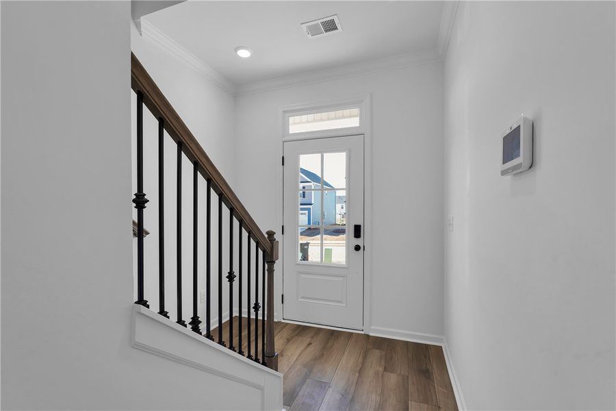 This bright entry features a hardwood staircase an