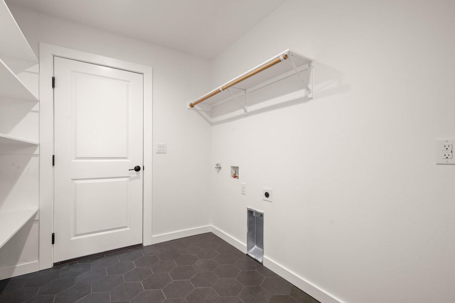 Laundry area with washer hookup, hookup for an electric dryer, gas dryer hookup, and dark tile patterned floors