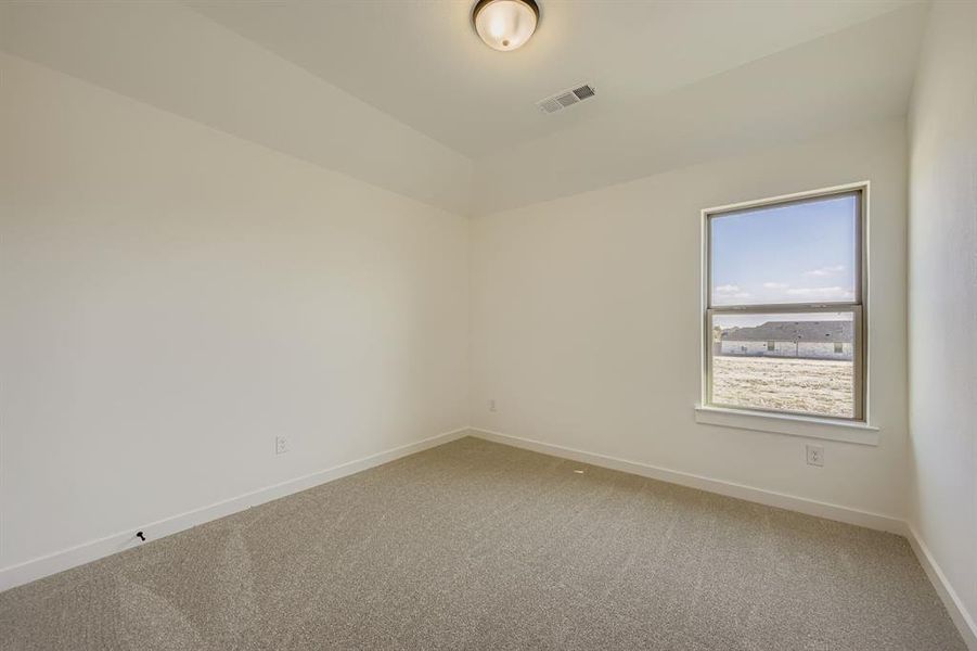 Carpeted spare room featuring baseboards