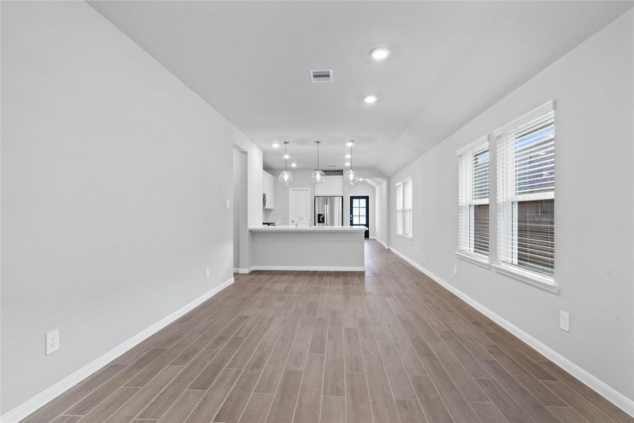 Enjoy meals in this sun-drenched space, featuring durable tile flooring, abundant natural light from the large windows (fitted with blinds), and recessed lighting.