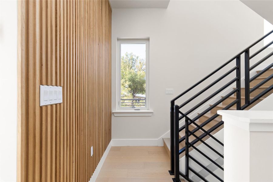 Natural wood paneling pairs with a modern staircase to create an elegant architectural transition.