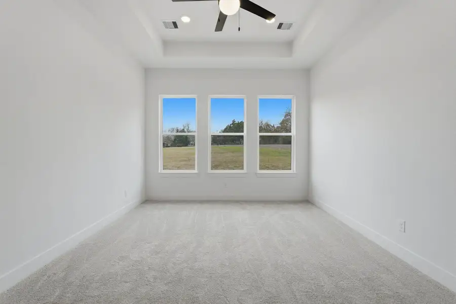 Primary bedroom offers a quiet retreat with natural light and direct access to the en-suite bath.