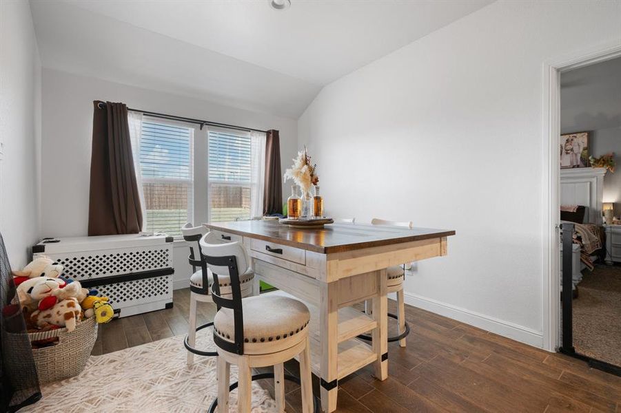Dining area featuring dark wood finished floors and vaulted ceiling Dining area featuring dark wood finished floors and vaulted ceiling