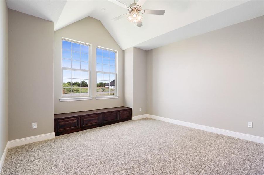 Empty room with carpet floors, lofted ceiling, and ceiling fan