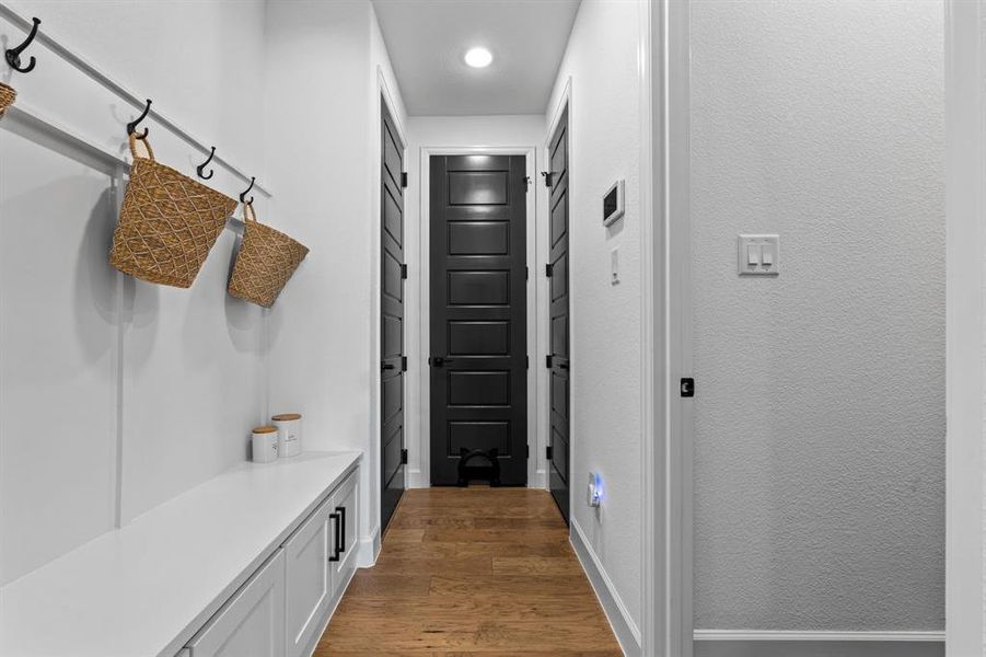 Mudroom featuring dark wood finished floors and a textured wall Mudroom featuring dark wood finished floors and a textured wall