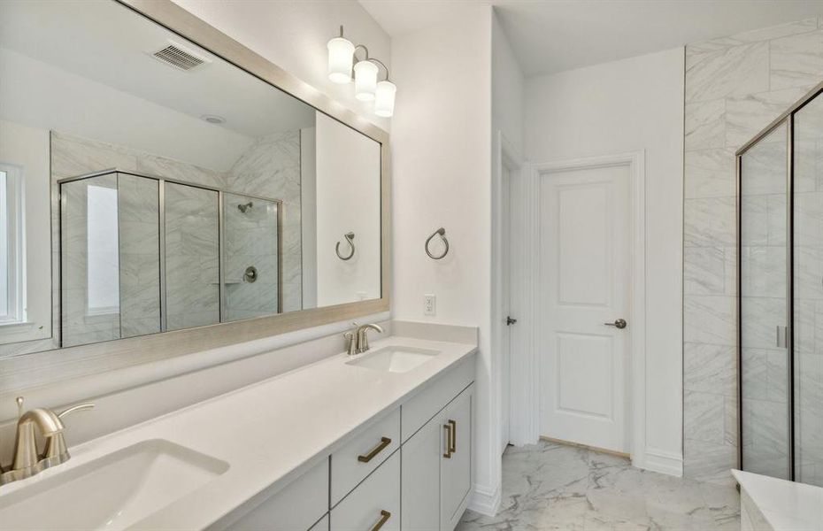 Elegant owner's bathroom with dual vanity and large shower*real home pictured