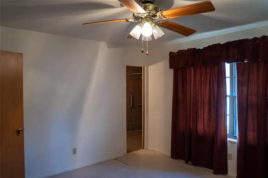 Spare room with carpet floors and a ceiling fan
