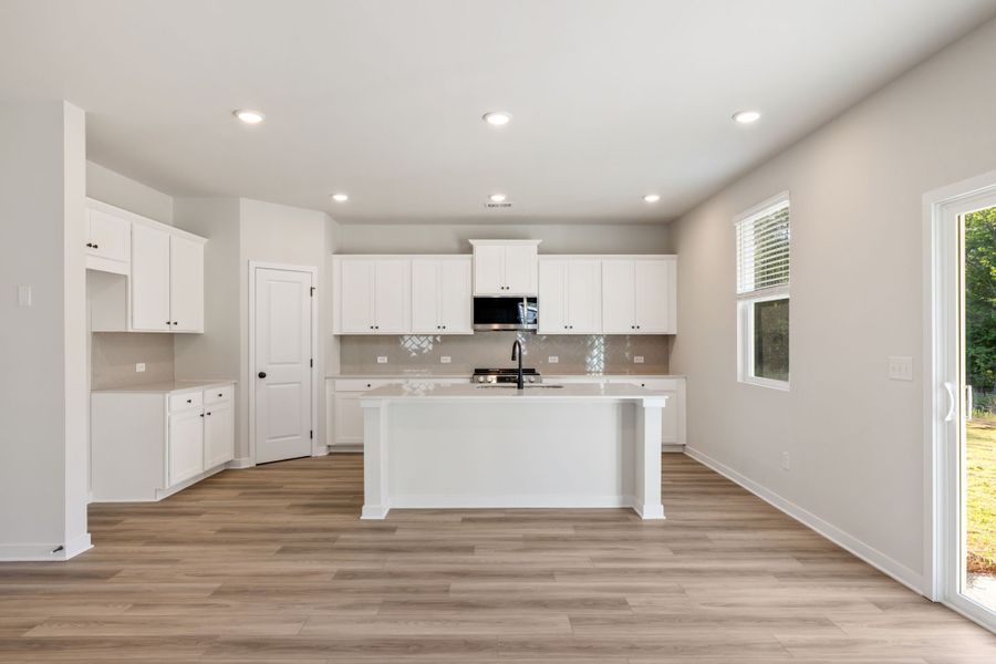 A kitchen with white cabinets.