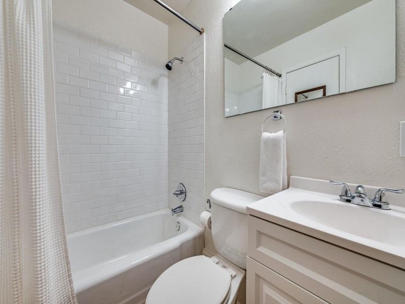Full bath with shower / bath combo, vanity, and a textured wall Full bath with shower / bath combo, vanity, and a textured wall