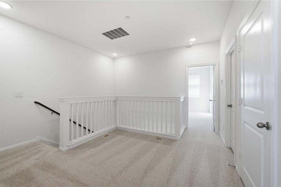 Corridor featuring an upstairs landing, light colored carpet, and recessed lighting Corridor featuring an upstairs landing, light colored carpet, and recessed lighting