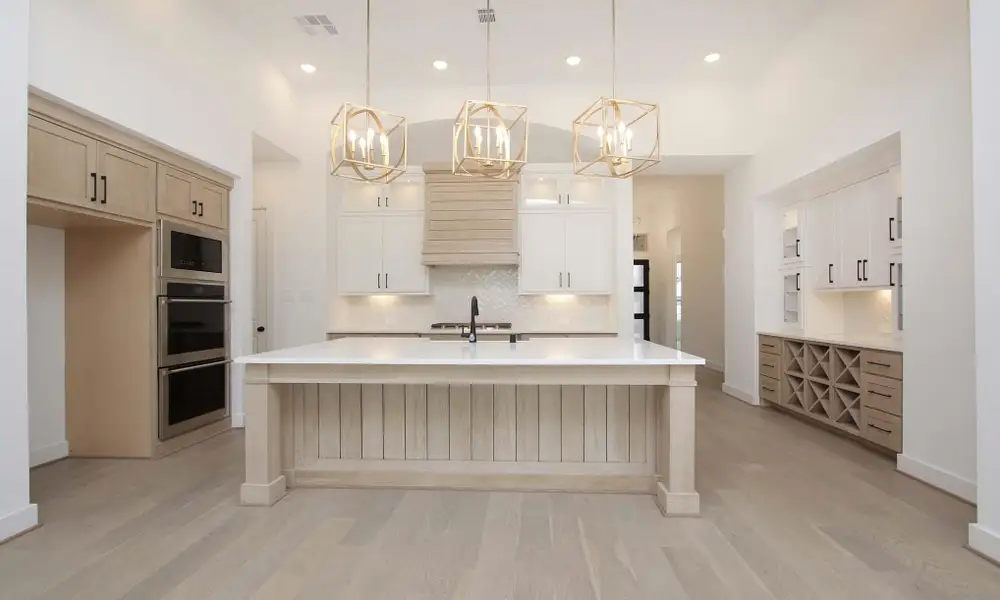 Kitchen with a chandelier, light wood-style flooring, backsplash, light countertops, and double oven
