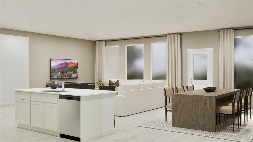 Kitchen featuring white cabinets, stainless steel dishwasher, a center island with sink, and light wood-style floors