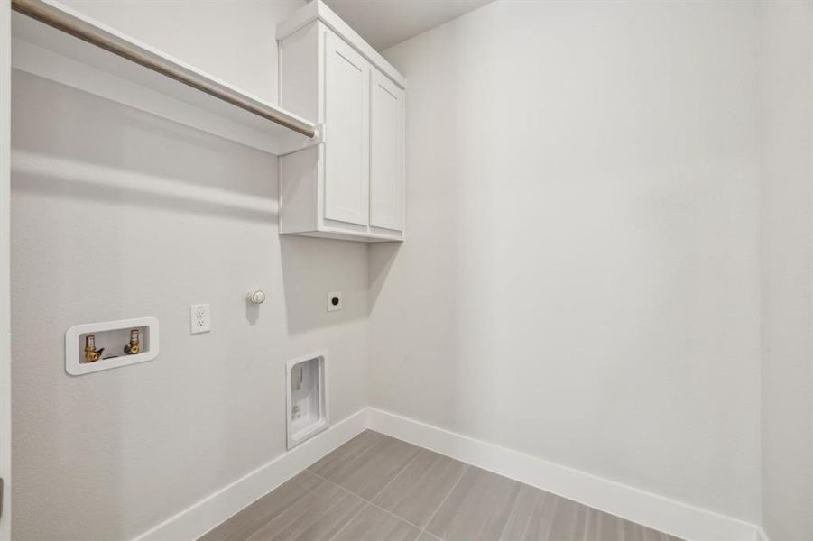 Washroom featuring cabinets, hookup for a gas dryer, hookup for a washing machine, and electric dryer hookup