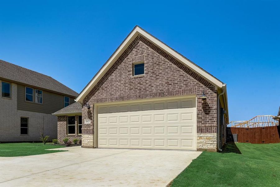 Front facade featuring a garage and a front lawn