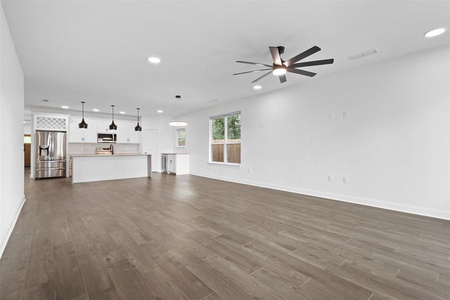 Unfurnished living room featuring recessed lighting, dark wood-style floors, and ceiling fan