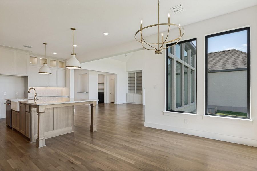 Polished hardwood floors and clean architectural lines define this expansive, sunlit open-concept living space.