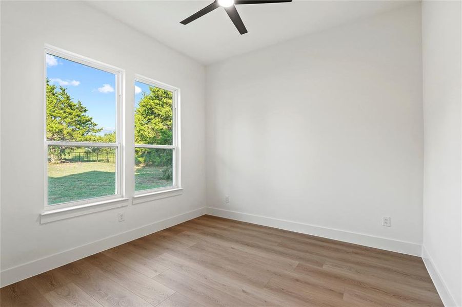 Empty room with wood finished floors and a ceiling fan Empty room with wood finished floors and a ceiling fan