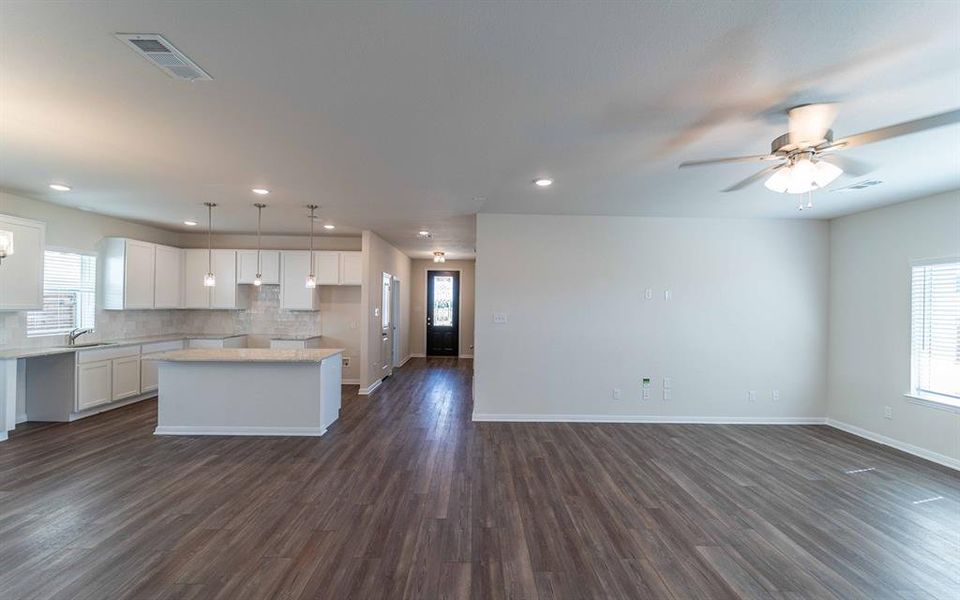 Open-concept living space featuring wood-finish flooring, a contemporary ceiling fan, and recessed lighting