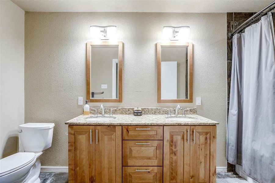 Primary bath with dual sinks & granite countertops.