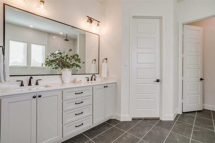 Bathroom with walk in shower, vanity, and tile patterned flooring