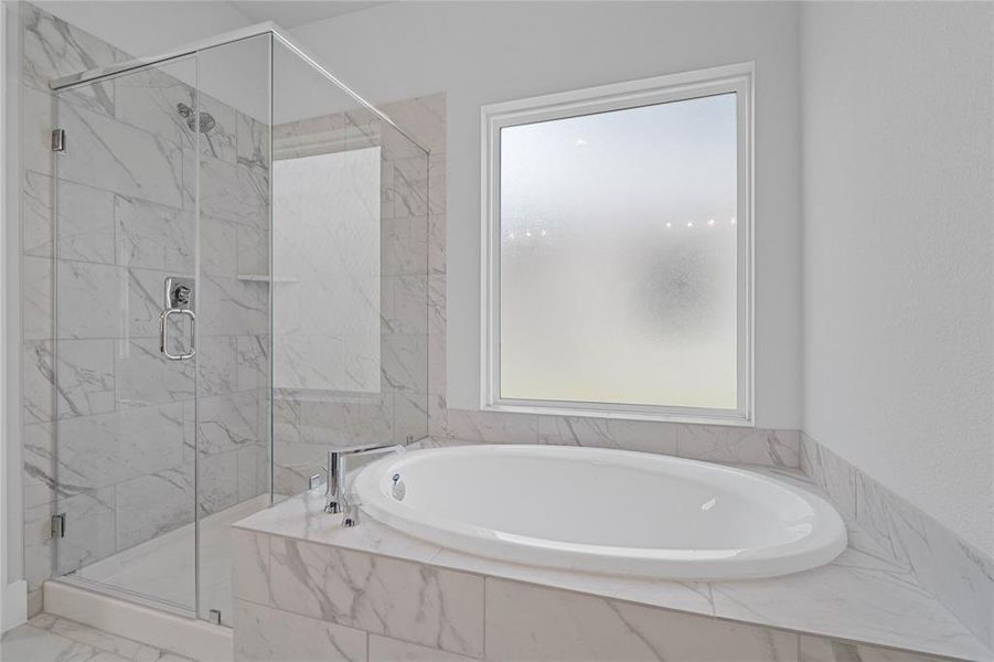 This additional view of the primary bath showcases a walk-in shower with tile surround and a separate garden tub perfect for soaking after a long day.