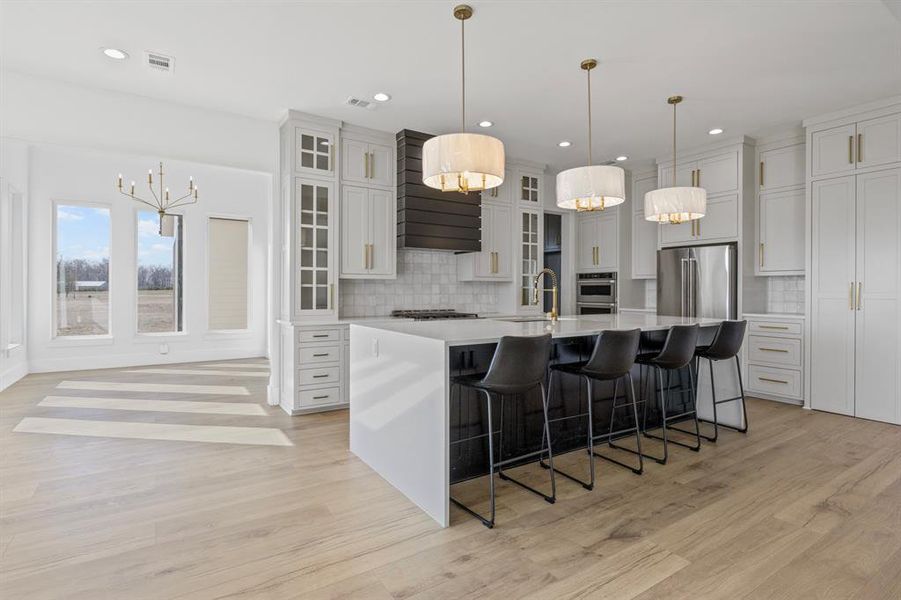 Kitchen with stainless steel appliances, a notable chandelier, light countertops, and a sink Kitchen with stainless steel appliances, a notable chandelier, light countertops, and a sink