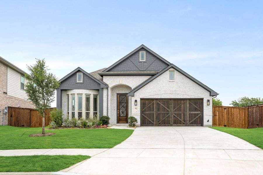 Single-story home with white brick exterior, dark wood garage doors, and arched entryway Single-story home with white brick exterior, dark wood garage doors, and arched entryway