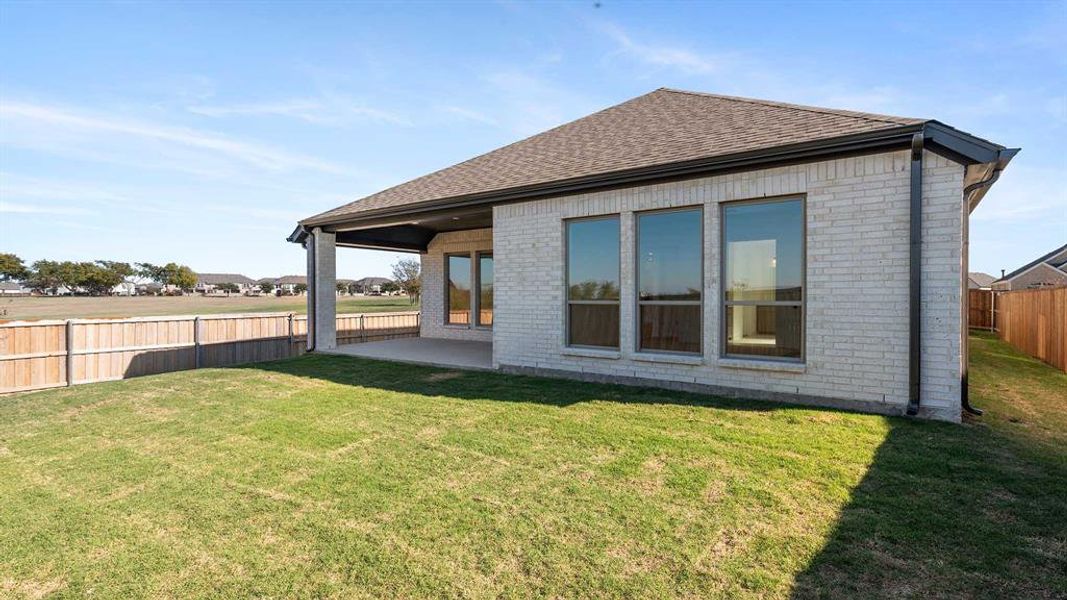 Rear view of house with a patio area and a yard