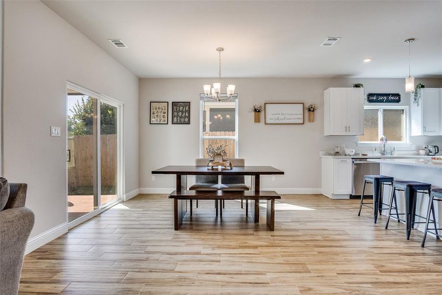 Dining area featuring light wood-style floors, a chandelier, and healthy amount of natural light