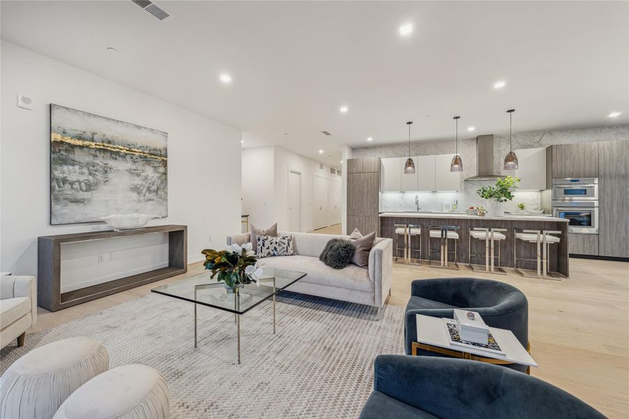 Open-concept kitchen and living area with engineered wood flooring throughout. Open-concept kitchen and living area with engineered wood flooring throughout.